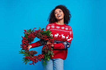 Photo of cheerful adorable girl wear trendy print sweater preparing new year looking empty space isolated on blue color background