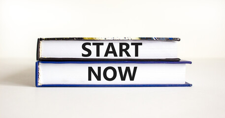 Start now symbol. Concept words Start now on beautiful books. Beautiful white table white background. Business marketing, motivational start now concept. Copy space.