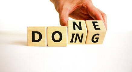 Doing and done symbol. Concept words Doing Done on wooden block. Beautiful white table white background. Businessman hand. Business doing and done concept. Copy space. © Dzmitry
