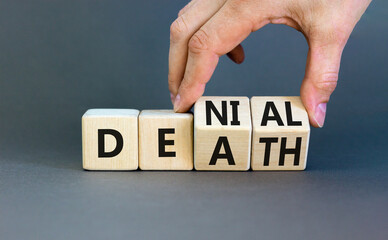 Denial death symbol. Concept words Denial Death on wooden block. Beautiful grey table grey background. Businessman hand. Business denial death concept. Copy space.