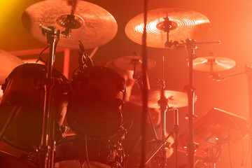 A close-up of a drum set in colorful lighting.