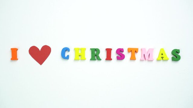 I Love Christmas text from colorful wooden letters and a beating paper red heart.