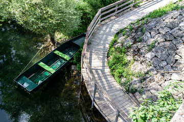 zielona łódka zacumowana przy drewnianym moście, Czarnogóra, Montenegro, Europe - obrazy, fototapety, plakaty