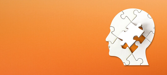 Brain shaped white jigsaw puzzle on colored background. Mental health and problems with memory.