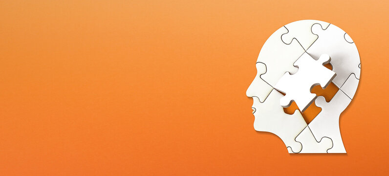 Brain shaped white jigsaw puzzle on colored background. Mental health and problems with memory.