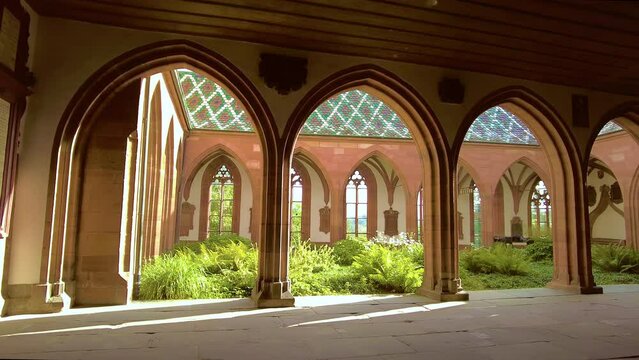 Panning inside the cloister courtyard garden which is located outside of St Nicholas Chapel at Basel Minster, a cathedral in the center of the old town of Basel, Switzerland.