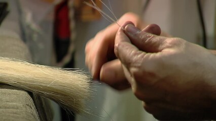 Craftsman Processing Violin Bow Hair in Workshop - Close Up