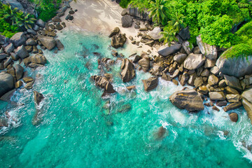 Bird eye drone shot of north east point beach, granite rocks, turquoise water, waves crashing, grenery, Mahe Seychelles