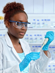 African female scientist or graduate student in lab coat loading samples