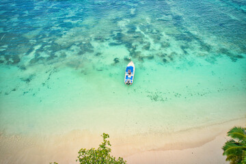 Drone of baie lazare beach, docking fisherman boat on low tide near the shore, turquoise water,...