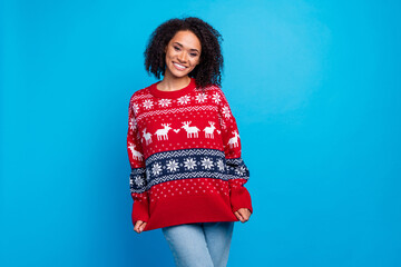 Photo of young funny woman showing her big ugly red sweater with reindeers print happy new year...