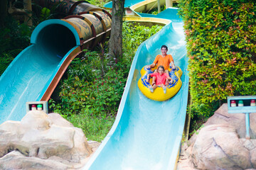 Kids on water slide. Family in aqua theme park.