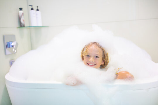 Child playing with foam in bath