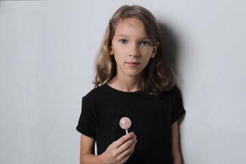 Girl child with candy on a stick, serious face