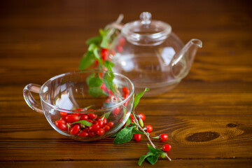 Branch with ripe red goji berry on wooden table