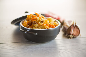 Cooked classic pilaf with meat, raisins, garlic and other ingredients in a bowl.