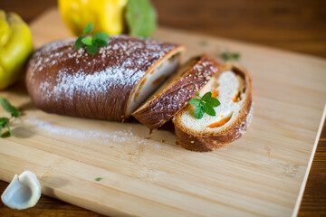 Cooked sweet pie with quince and pumpkin inside, yeast dough roll.