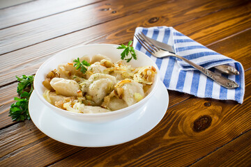 Ukrainian Vareniky or Pierogi stuffed with potato and mushrooms, served with fried onion.