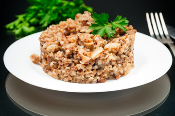 cooked buckwheat boiled with mushroom filling in a plate
