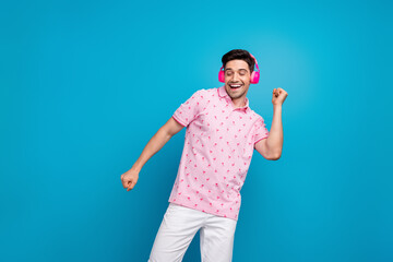 Photo of overjoyed carefree person enjoy favorite music headphones dancing chilling isolated on blue color background