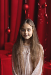 close up portrait of Cute little girl with long hair in dress on the  background Christmas. Xmas holiday concept