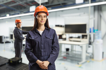 Young female technician with a helmet and goggles at a solar panel factory