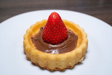 Small cake with a strawberry and chocolate cream