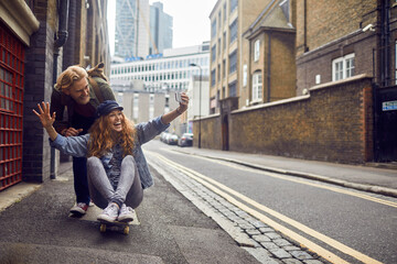 Playful couple enjoying a ride on a skateboard in an urban alley