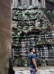 Fototapeta na wymiar Caucasian Tourist Enjoying and Exploring The Temples Of Angkor Wat In Cambodia