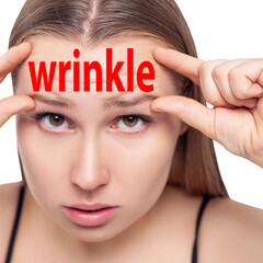 Beautiful woman with word WRINKLE on forehead.