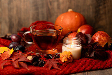 Cup of tea, candle, autumn fruits on the table. Autumn Evening Mood