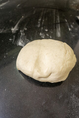 Fresh pizza dough balls on a rustic countertop at a pizzeria, ready for rolling and shaping.