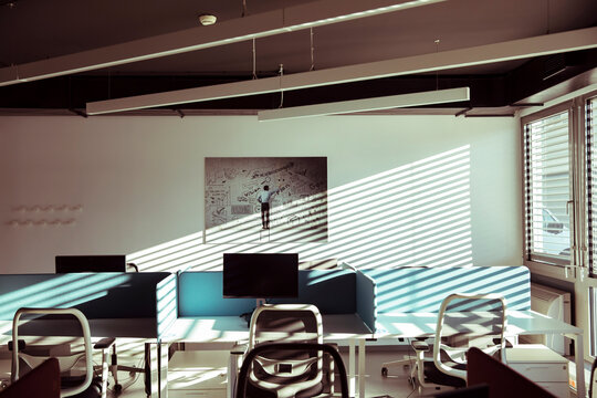 A modern office illuminated by sunlight casting diagonal shadows