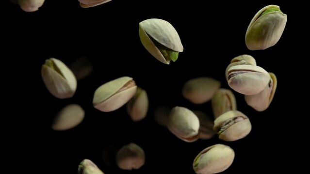 Pistachios are flying closeup on a black background