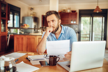 Man deeply contemplating a document in his home office