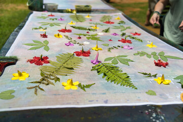 client placing ferns on cloth for pareo making, Mahe Seychelles