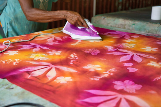 dark skin hand ironing with high heat the pareo to seal the printing ink, Mahe,Seychelles 3