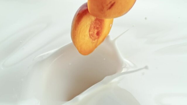 Peach Halves Falling into Creamy Milk Making Swirly Splashes in Macro and Slow Motion 1000 fps