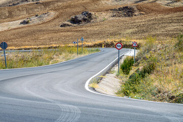 Fototapeta premium Road in the countryside leading to small village surrounding by farm lands, Ronda, Spain