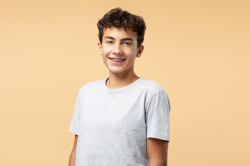 Portrait of positive teenager boy with dental braces wearing casual clothes, looking at camera