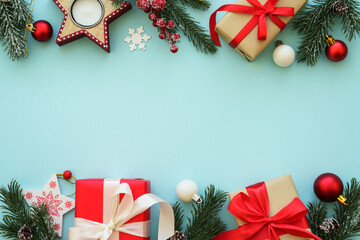 Christmas presents and decorations with fir tree at blue background. Flat lay image with copy space.