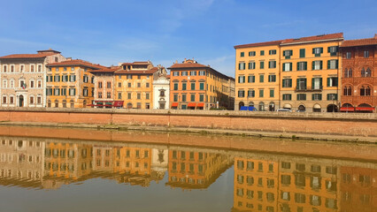 Fototapeta na wymiar The street of Pisa is reflected in the river Arno.
