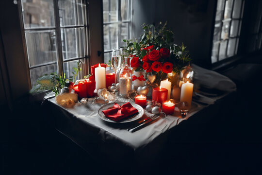 Romantique table dréssée pour la Saint Valentin, Noël, Nouvel an, ou Nouvel an chinois dans les couleurs rouge et or pour repas aux chandelles avec bouquet de fleurs