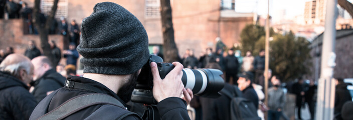 photographer hand camera in the demonstration - obrazy, fototapety, plakaty