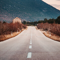 Asphalt road panorama in countryside on cloudy day. Road in forest under dramatic cloudy sky. Image of wide open prairie with a paved highway stretching out as far as the eye can see. - 671266158