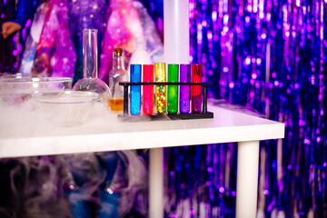 Colorful test tubes and lab equipment set against a shiny purple background, ideal for science-themed visuals.
