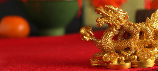 Golden figurine of Chinese dragon on table. Banner for design