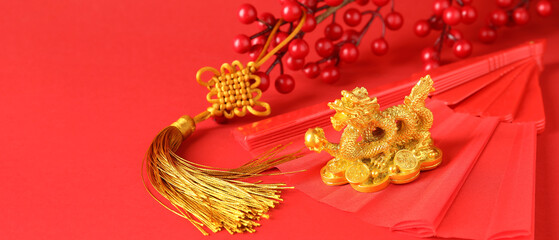 Golden figurine of Chinese dragon, paper fan and amulet on red background with space for text