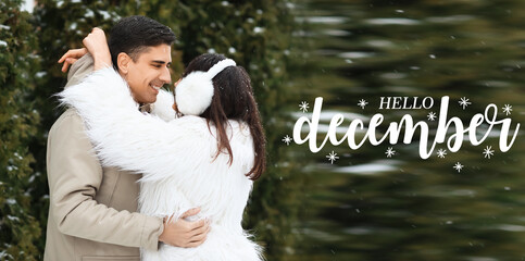 Loving couple hugging on snowy winter day and text HELLO, DECEMBER