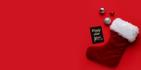 Christmas sock with balls and greeting card on red background with space for text